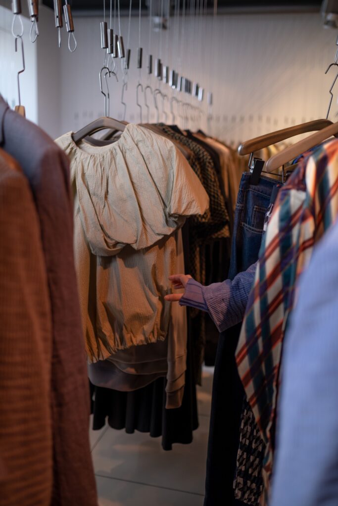 Explore this intimate view of a clothing rack in a modern fashion boutique, showcasing diverse apparel.